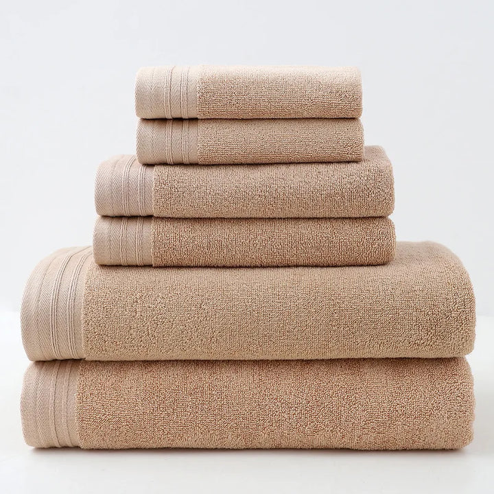 Beige cotton bath towel set, stacked rolled towels with solid terry texture