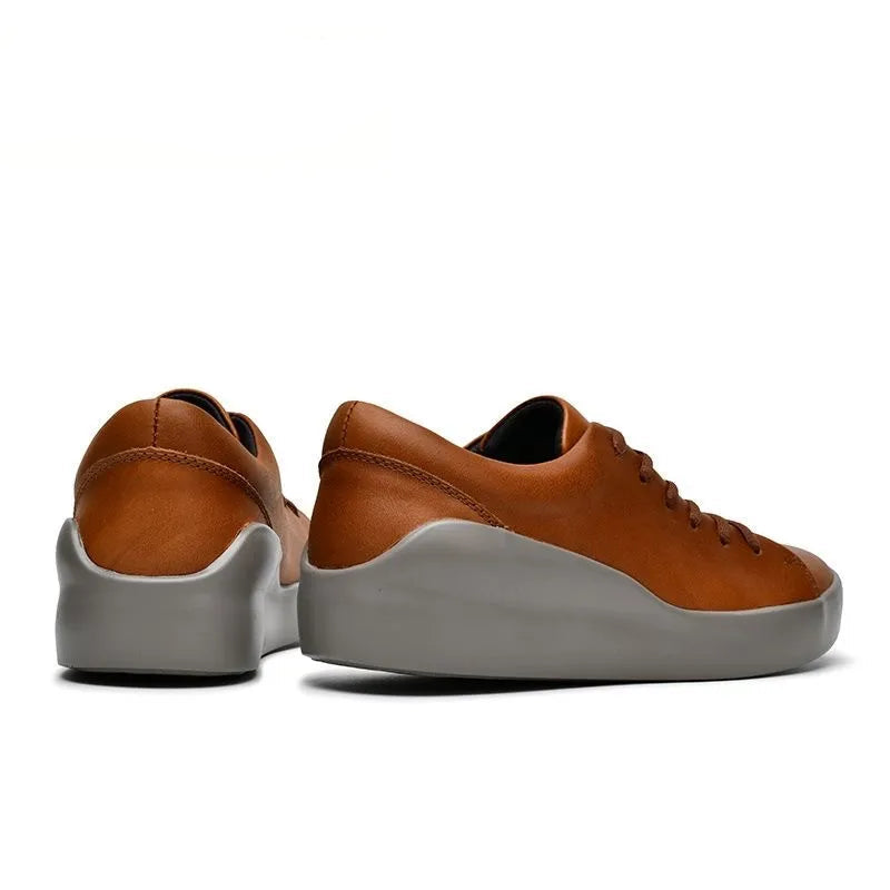 A pair of U-CCO Leisure Brand low-top sneakers shown from the side and back angles on a white background. The shoes feature a warm brown leather upper and a thick, flexible gray sole.