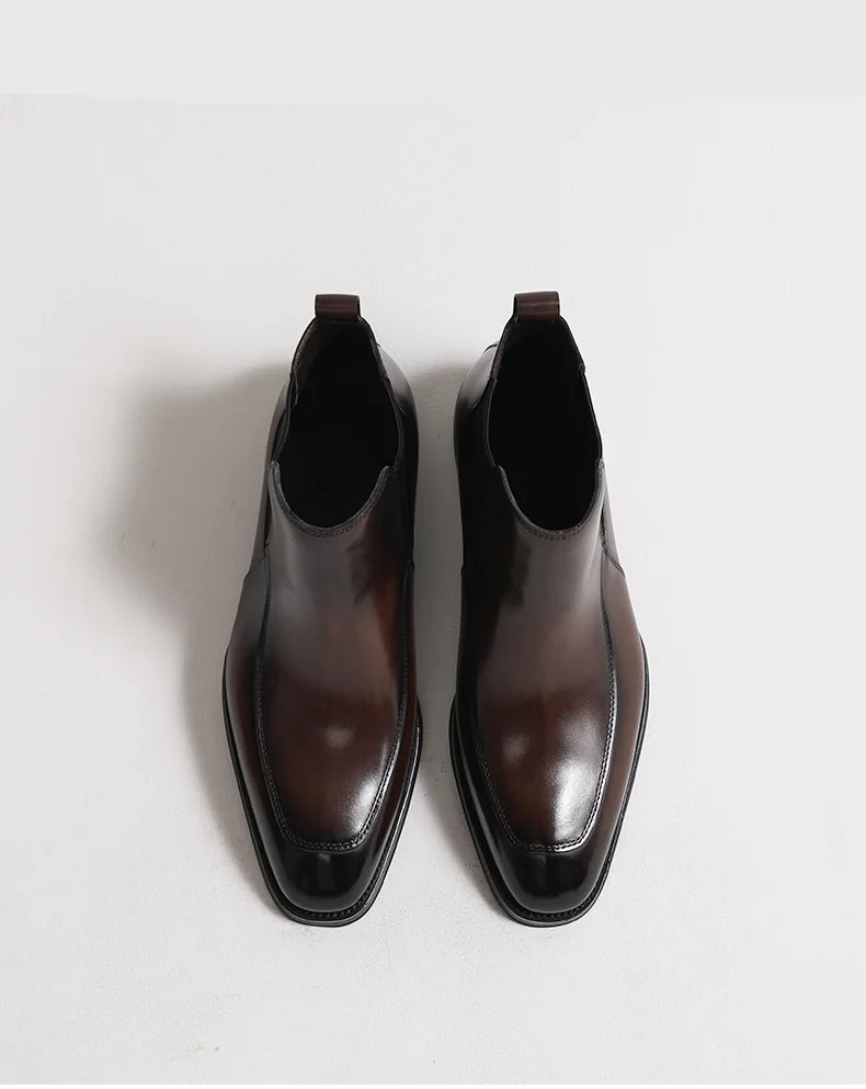 Pair of dark brown leather boots on a light gray background