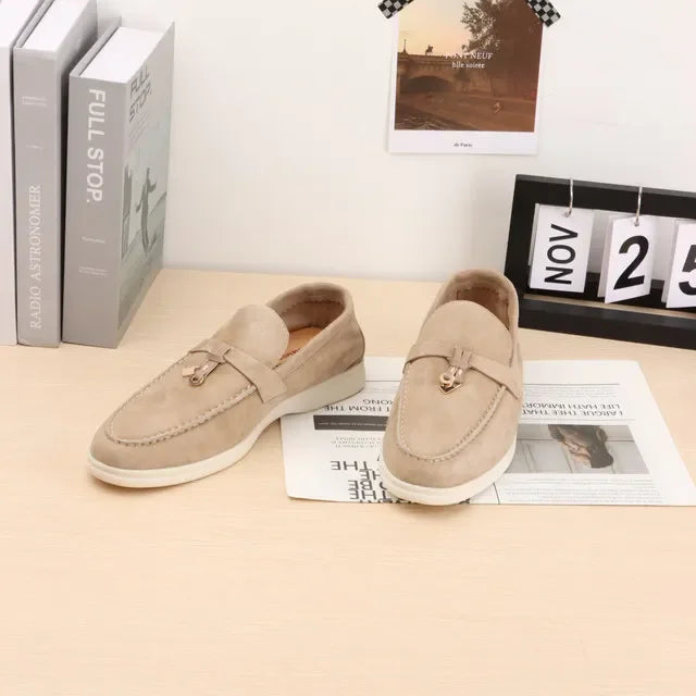 Light beige suede slip-on loafers with metal bit detail and white sole