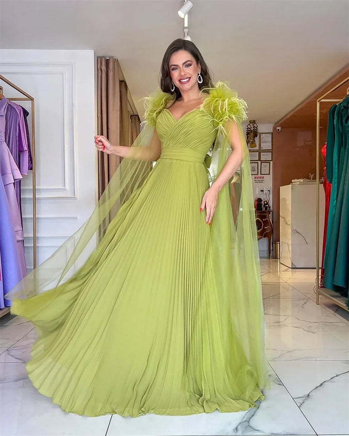 Light green formal evening gown with V-neck, flowing pleated skirt, and feathered straps