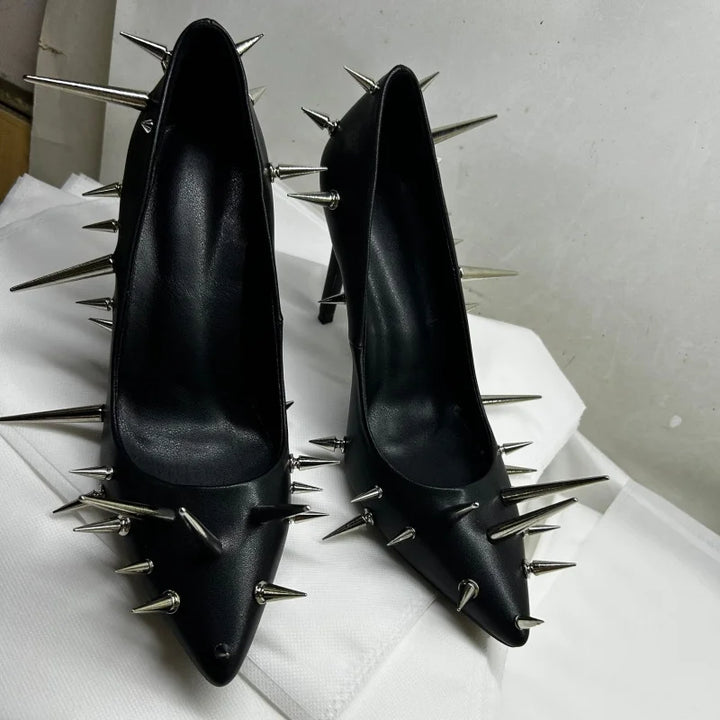 Pair of black patent leather heel pumps with silver spike rivets and pointed toe