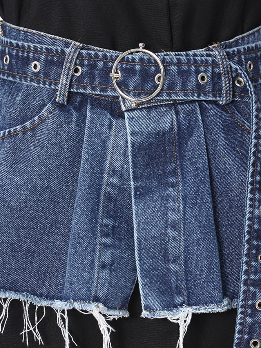 Close-up of blue denim belt with round buckle and stitched pleated skirt panel