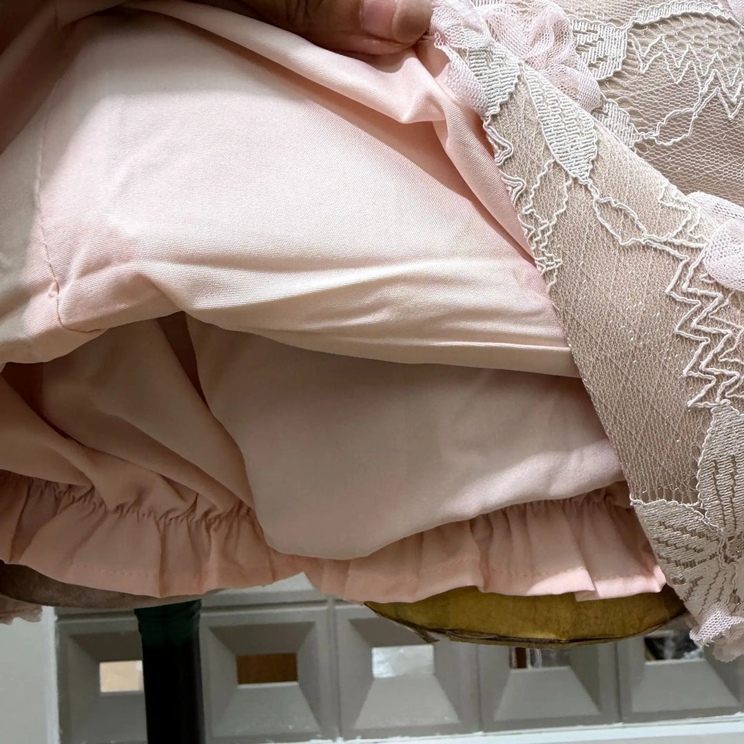 Pale pink corset bodice with lace trim and textured fabric, close-up