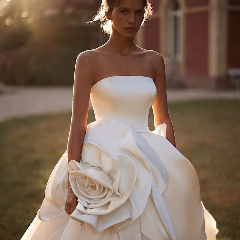 White strapless bridal gown with oversized fabric flower rosette and fitted bodice