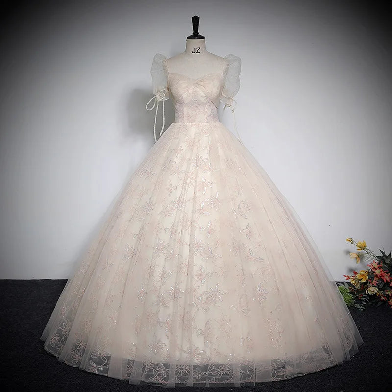 Champagne beige shiny ball gown with puff sleeves, bow ties, and full tulle skirt