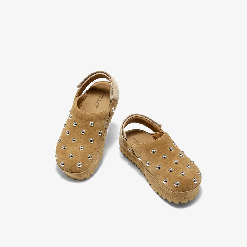 Tan sandals with stud details on a white background