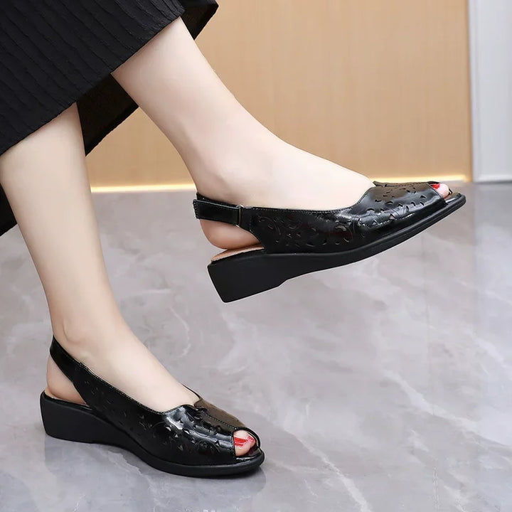 Women’s open-toe leather wedge sandals in black with perforated texture and peep-toe opening
