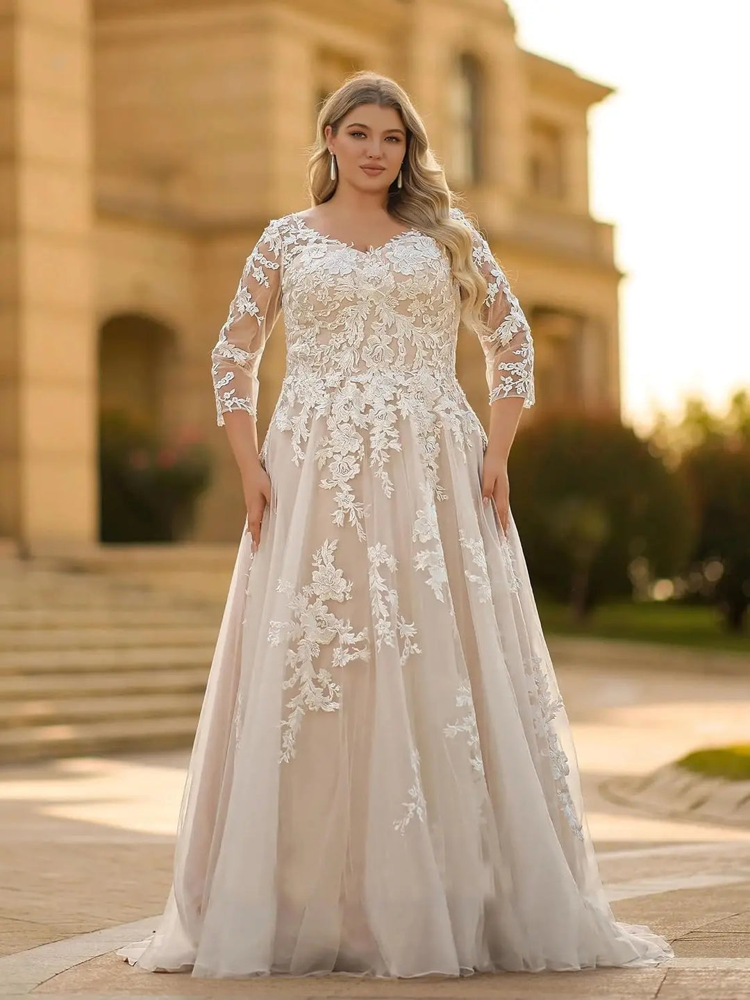 Ivory lace plus-size wedding dress with lace-covered bodice, 3/4 sleeves, and voluminous skirt.
