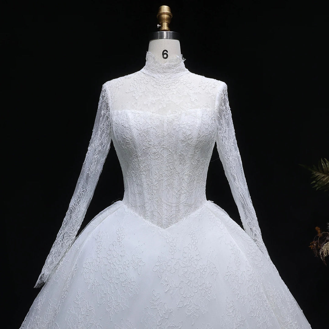 White lace high-neck wedding gown on mannequin, long lace sleeves and fitted bodice