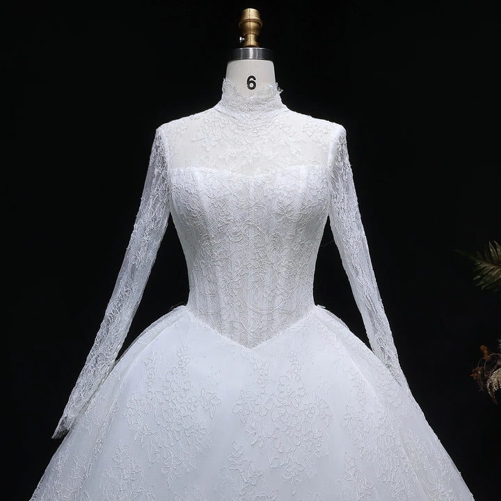 White lace high-neck wedding gown on mannequin, long lace sleeves and fitted bodice