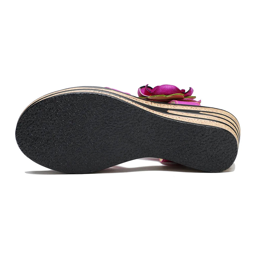 Women’s leather wedge sandal outsole, dark tread on bottom with pink upper and rose detail