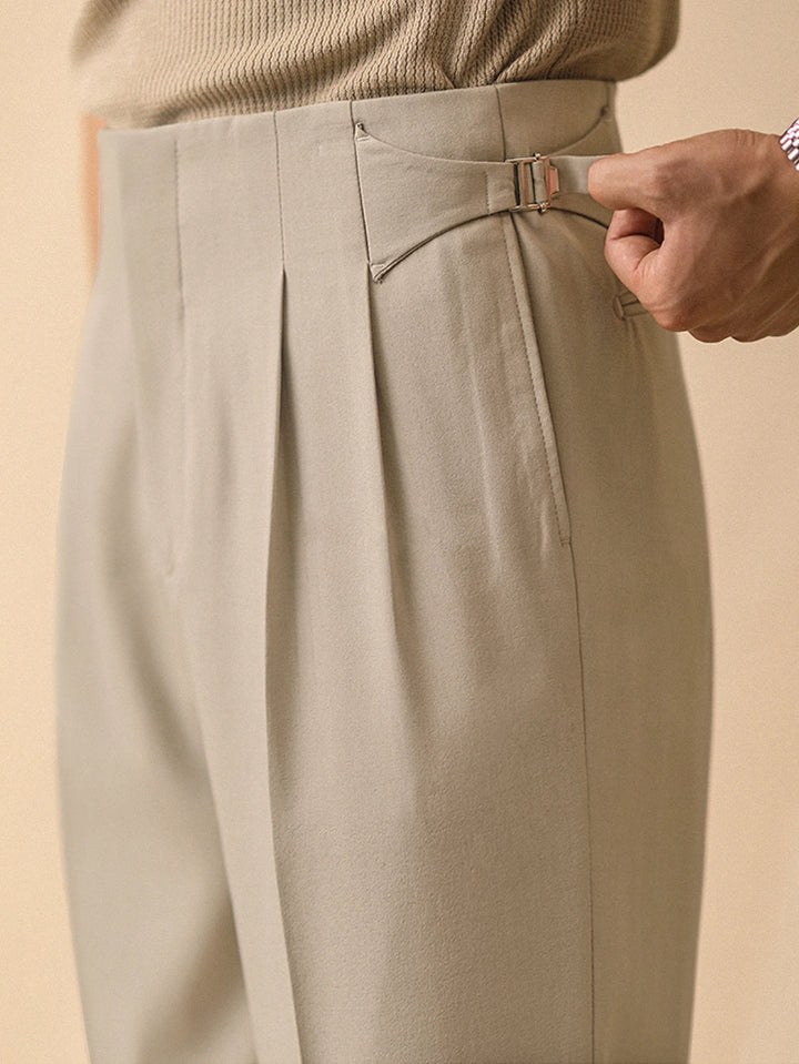 Champagne beige wide-leg pleated pants with belt loops and buckle, side close-up
