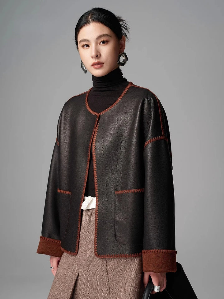 Women’s black goatskin short leather jacket with V-front and brown cuff trim