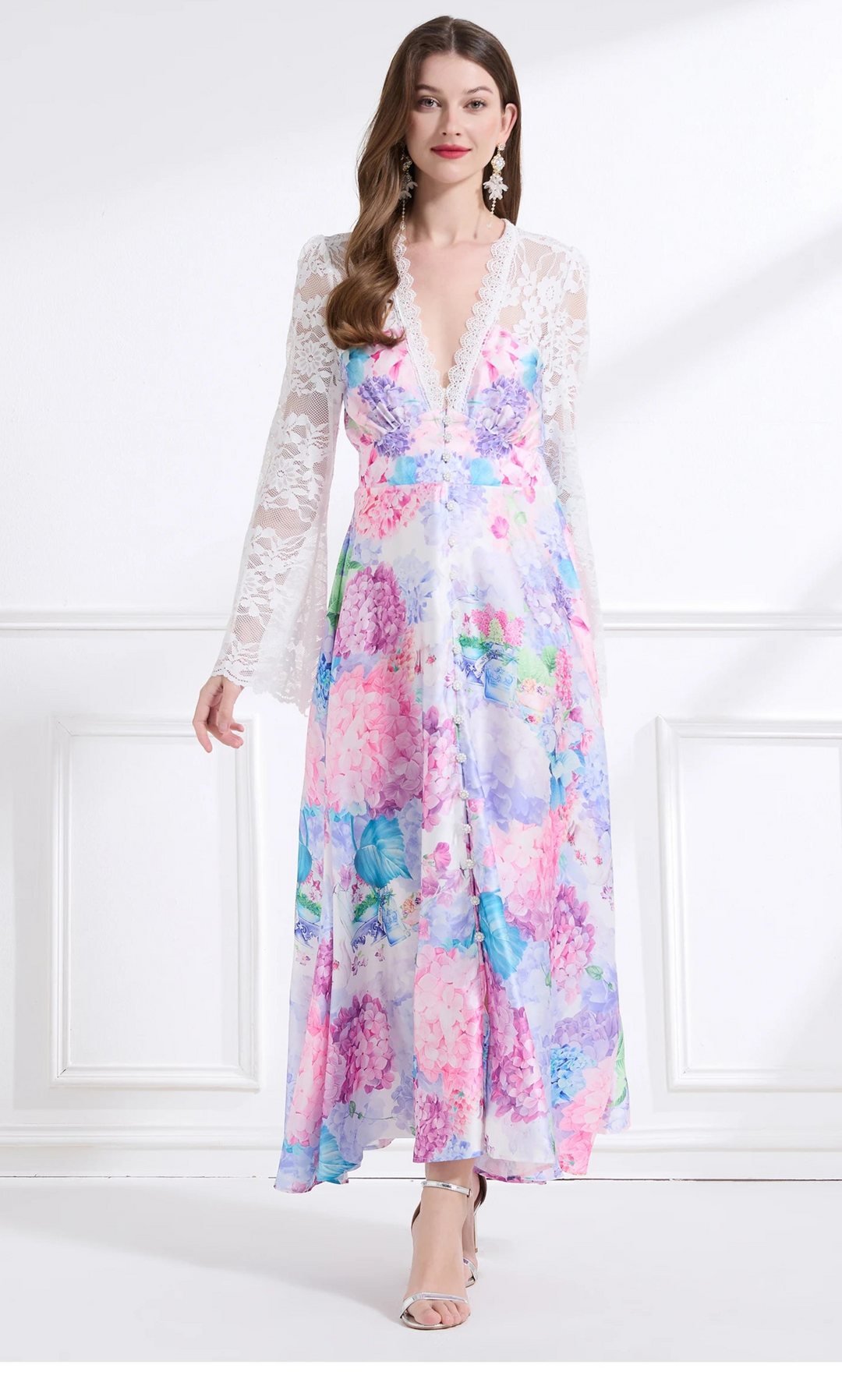 Woman wearing a colorful floral dress in a minimal white room.