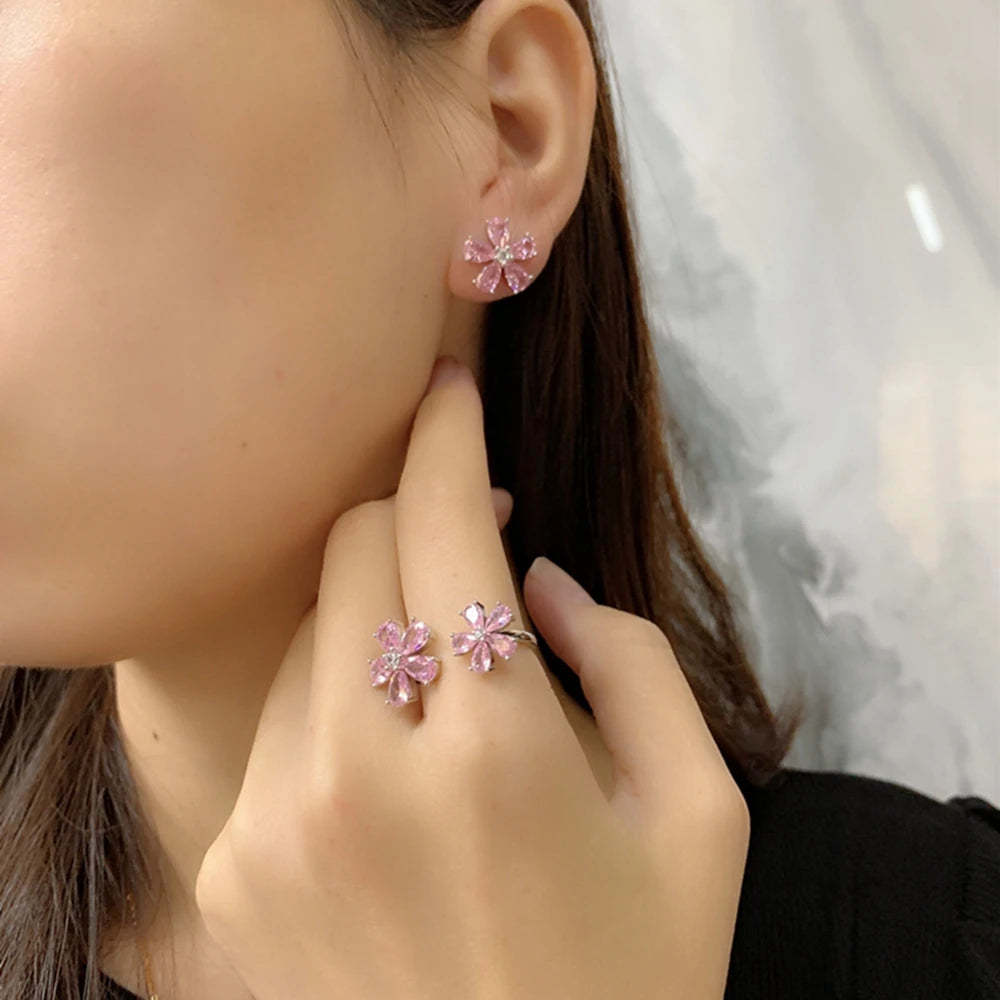 Pink flower stud earring on model with six teardrop stones and silver-tone prongs
