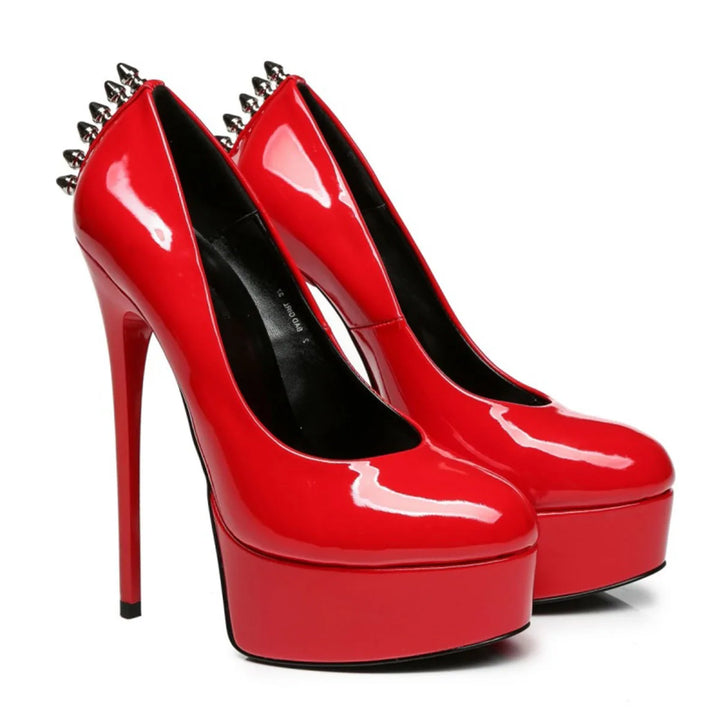 Red patent leather platform rivet heel pumps, angled view with black lining and spike accents