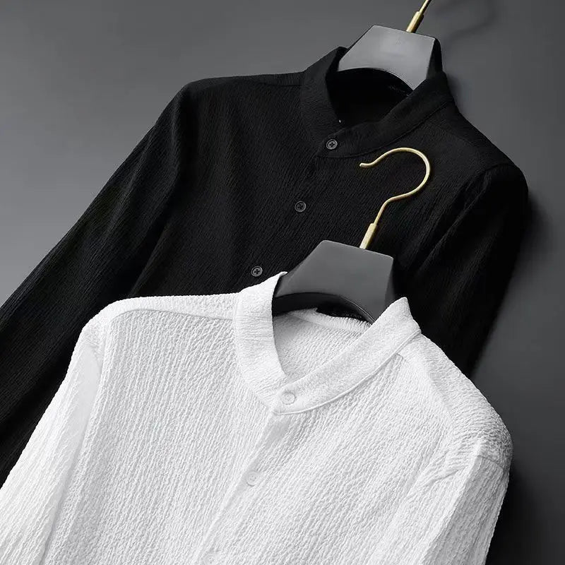 Black textured button-up shirt and white collared shirt on hangers