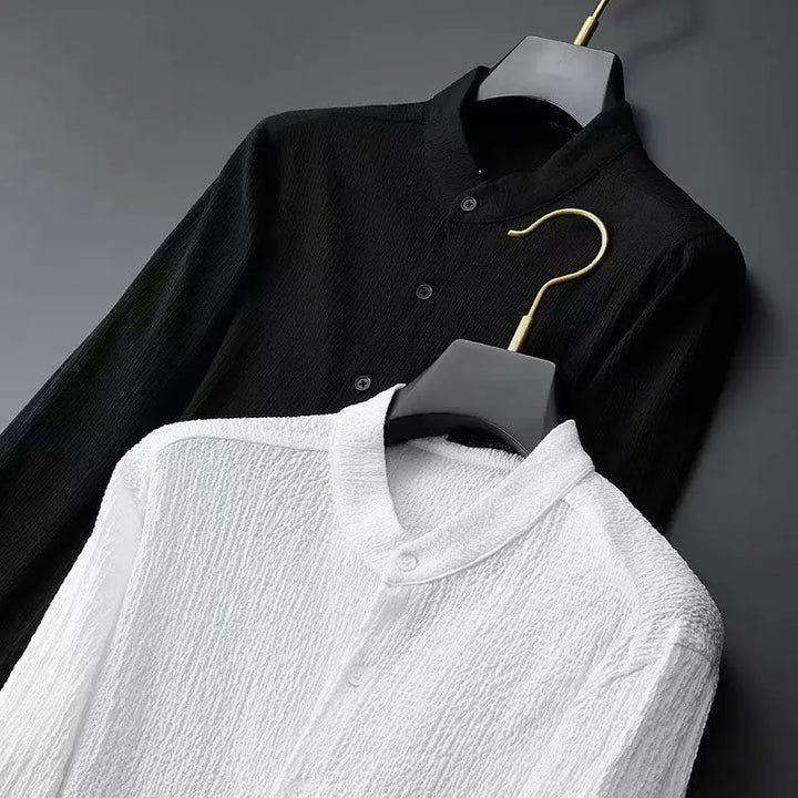 Black textured button-up shirt and white collared shirt on hangers