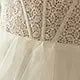 Close-up of white lace corset detailing on tulle bridal gown fabric