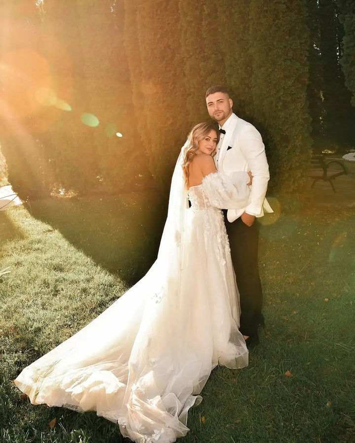 Ivory bridal gown with flowing tulle skirt and lace bodice, full-length outdoor view