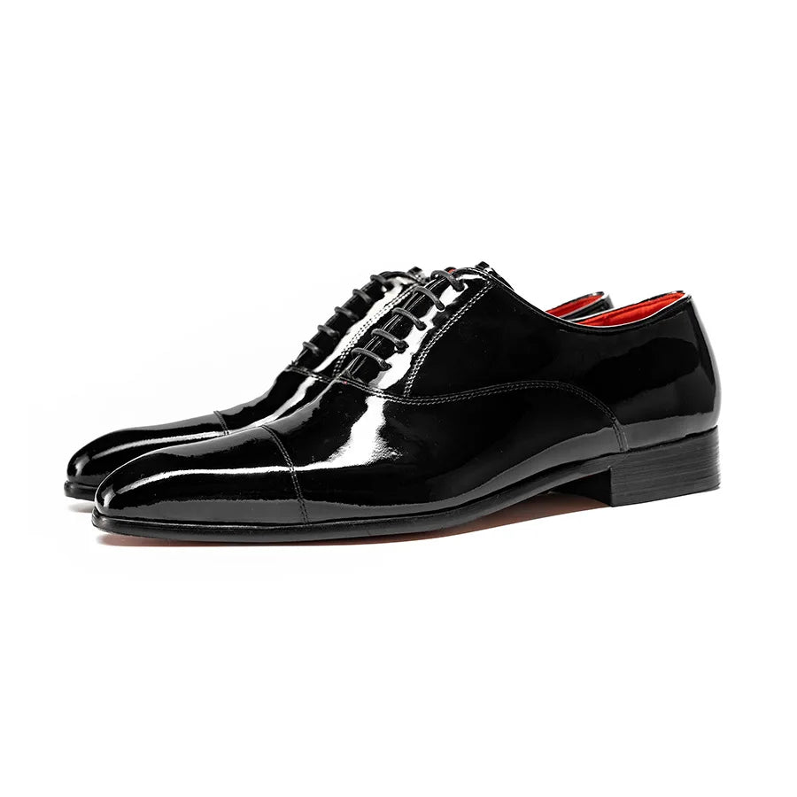 Black glossy lace-up oxford shoes, side profile view on white background
