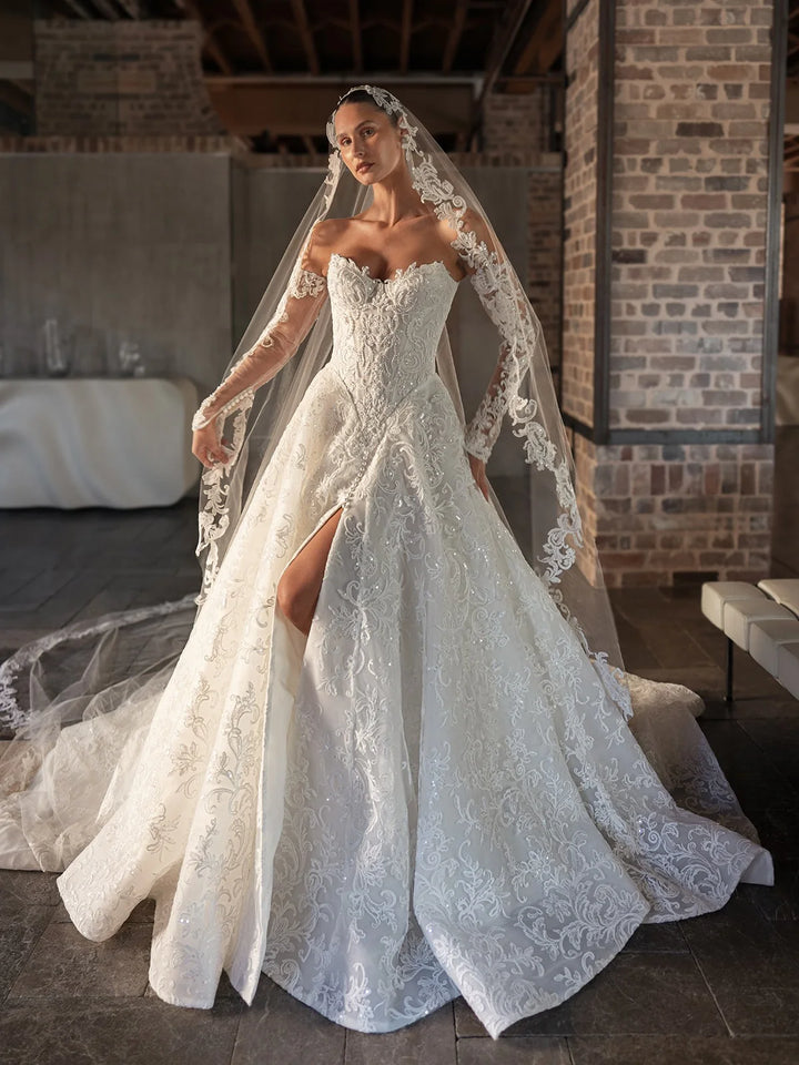 White bridal lace gown with sweetheart bodice, long sleeves, high slit and flowing veil