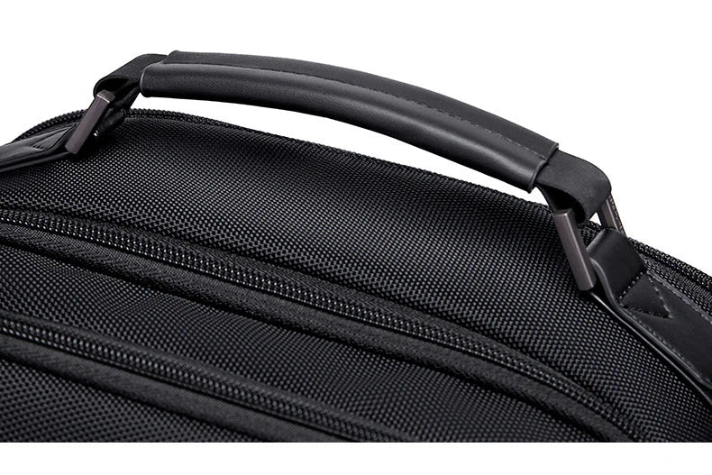 Black backpack handle and top edge with textured surface and zipper trim
