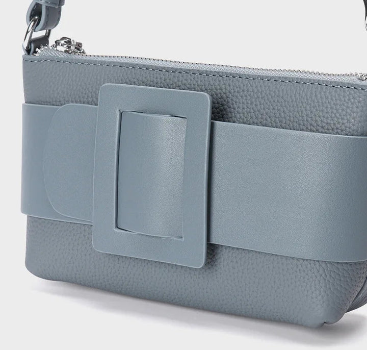 Gray handbag with a decorative buckle on a white background