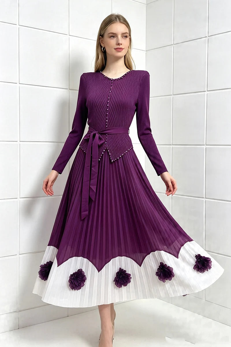 Purple pleated midi party dress with long sleeves, tie waist, scalloped hem with pom detail.