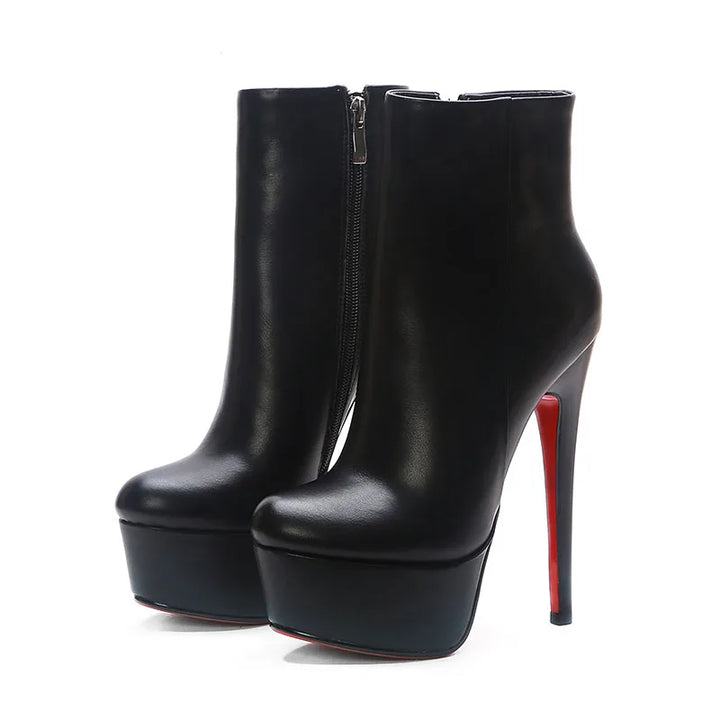 Pair of black platform ankle boots with side zipper and tall stiletto heels.