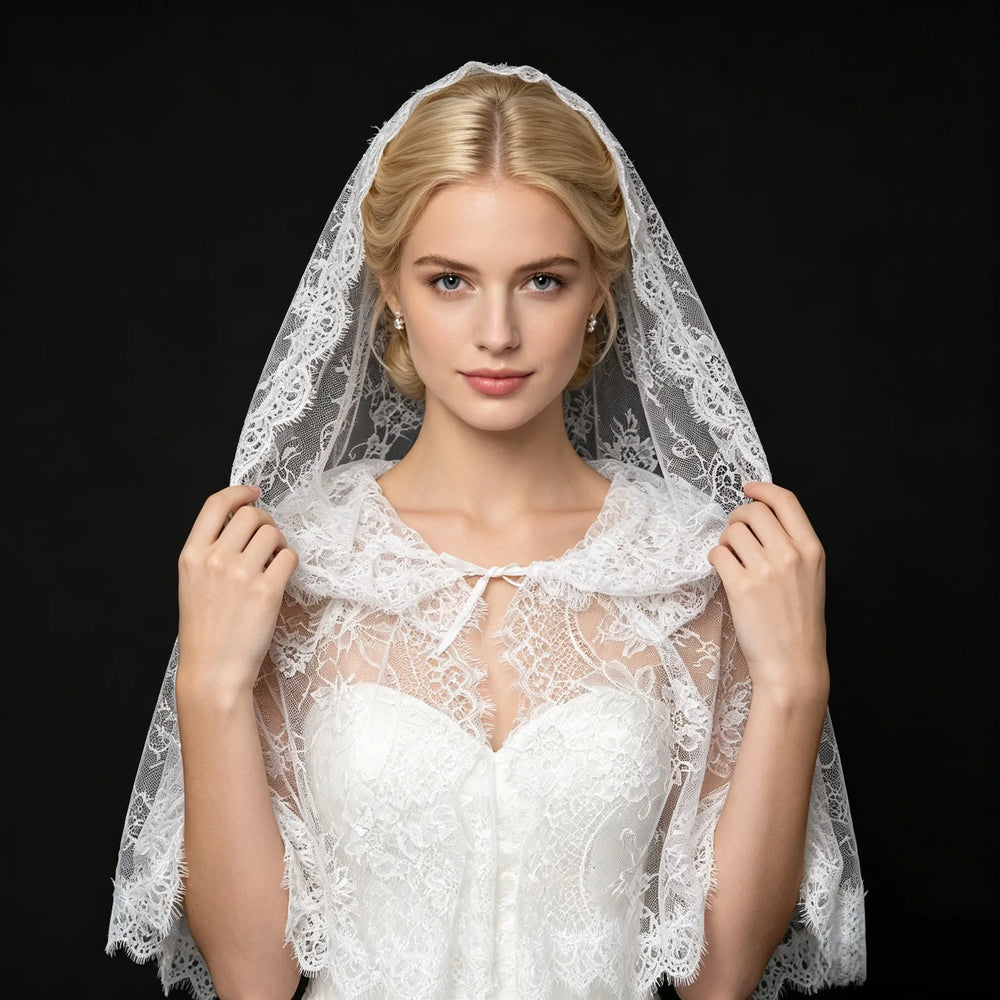 Off-white hooded lace bridal cape with floral pattern, scalloped edges, and tie neck