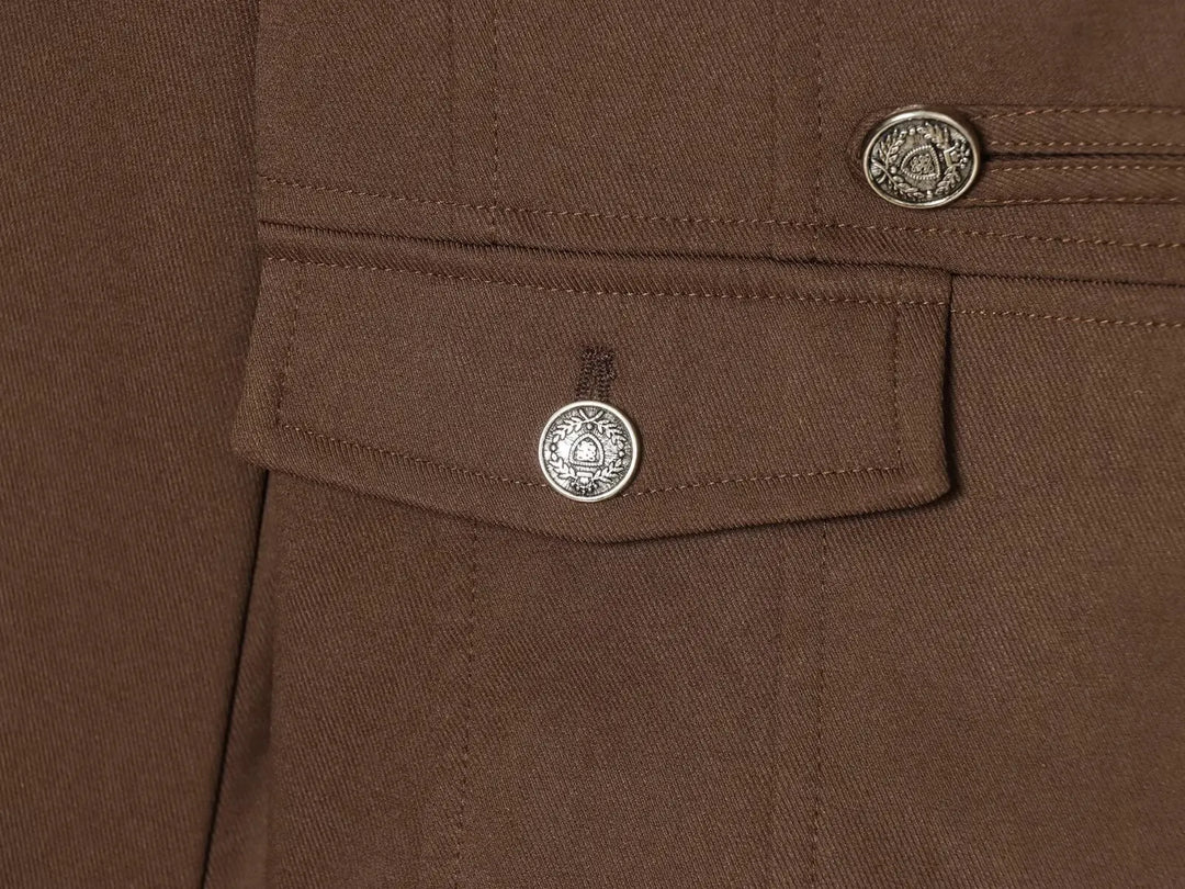 Brown blazer chest pocket with round silver button and visible topstitching
