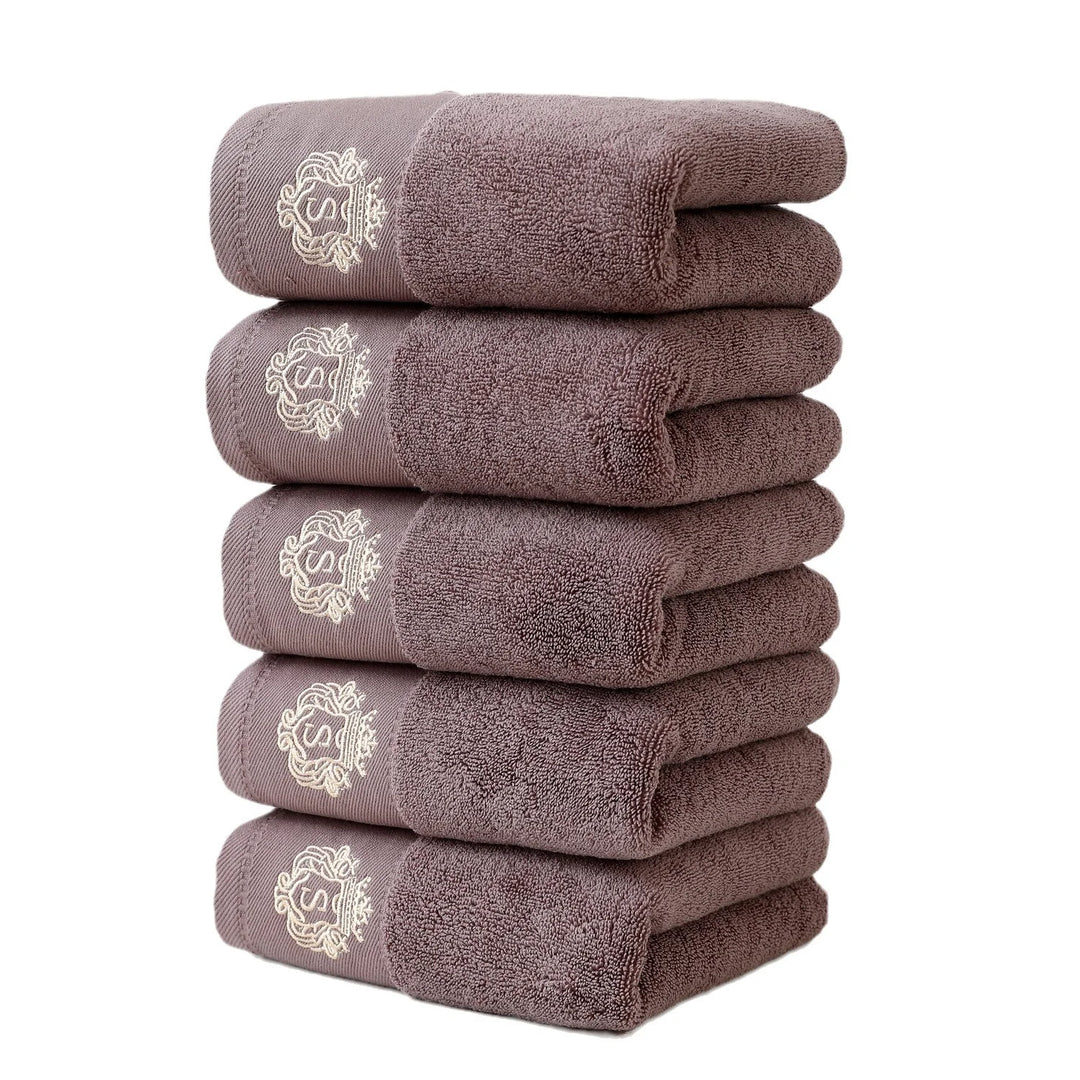 Brown 5-piece bathroom towel set with gold embroidered monograms, folded stack