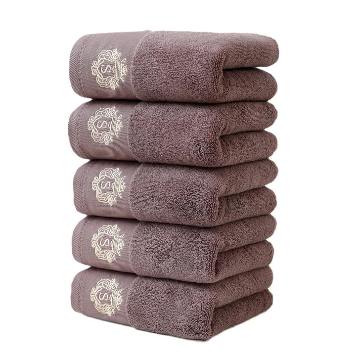 Brown 5-piece bathroom towel set with gold embroidered monograms, folded stack