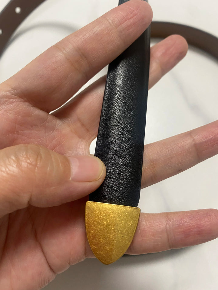 Black leather belt with smooth narrow strap and gold-tone pointed keeper tab