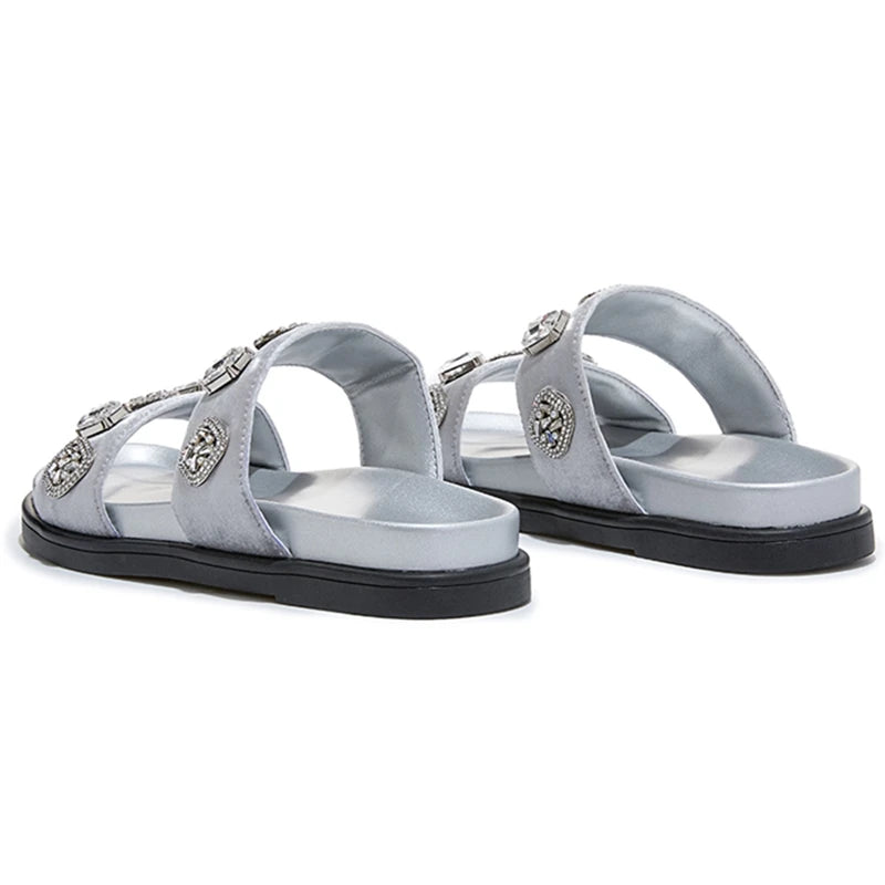 Light gray flat slide slippers with jeweled cross straps and open-toe design