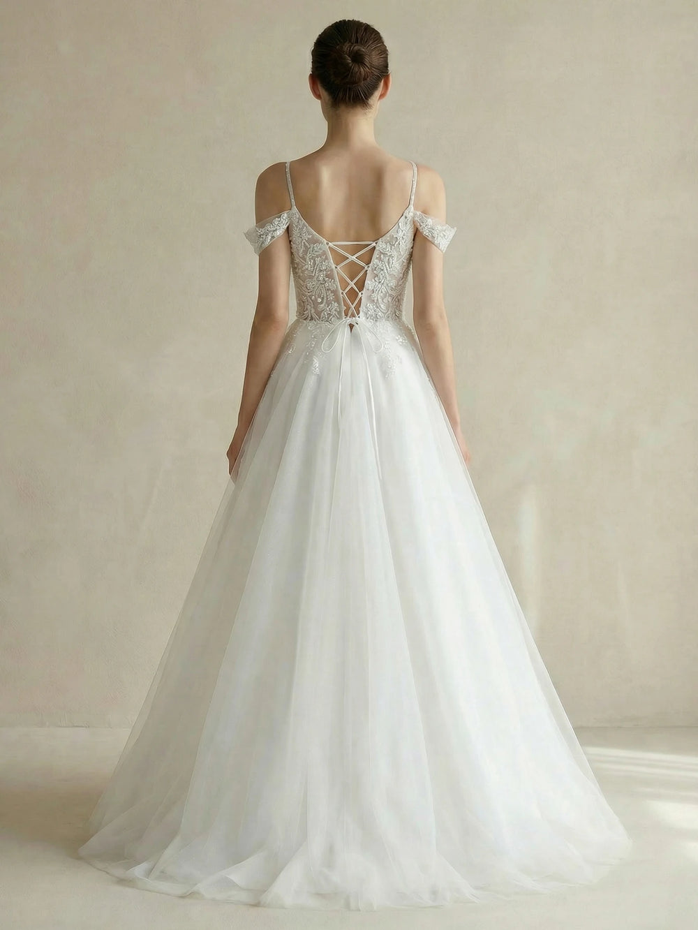 White bridal gown back view with lace-up detail, off-shoulder sleeves, full tulle skirt