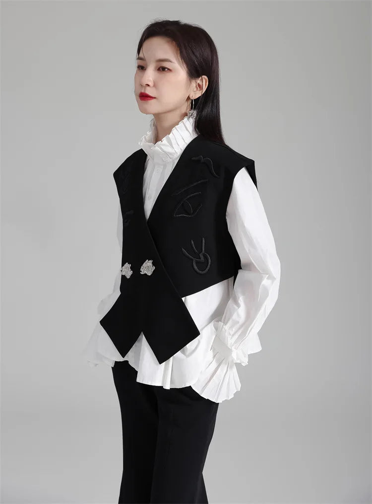 Black irregular women’s suit waistcoat with V-neck, decorative motifs, and silver buttons.