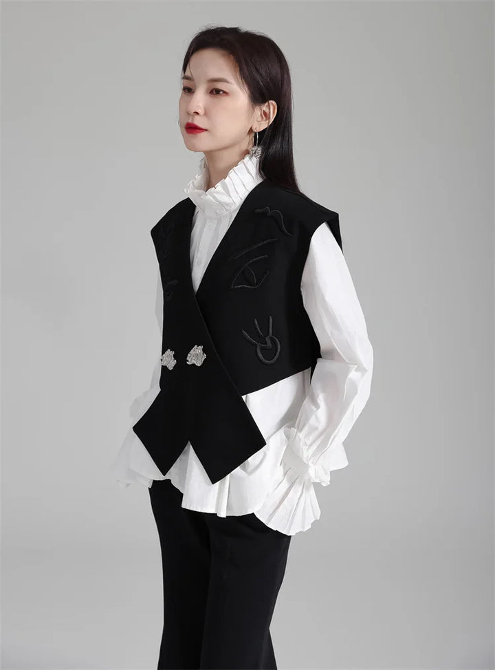 Black irregular women’s suit waistcoat with V-neck, decorative motifs, and silver buttons.