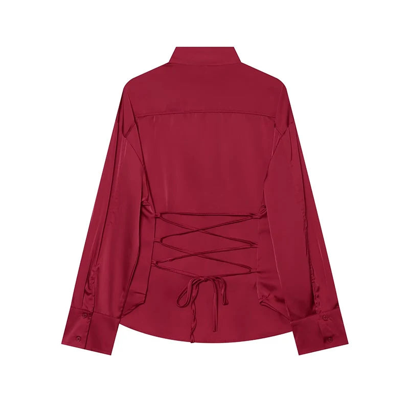 Red satin blouse back view with lace-up detail at yoke and long sleeves.