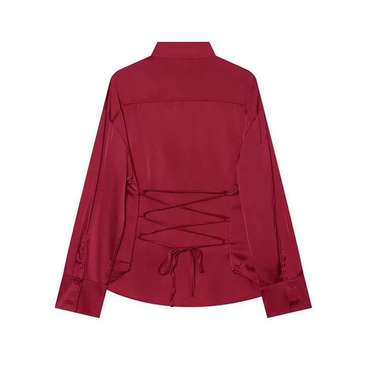 Red satin blouse back view with lace-up detail at yoke and long sleeves.