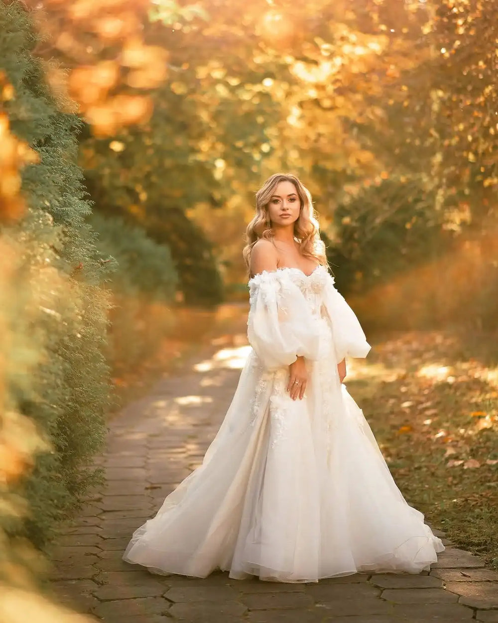 Ivory bridal gown with off-shoulder neckline, lace corset bodice, and full tulle skirt