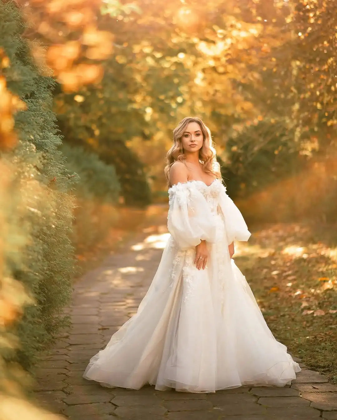 Ivory bridal gown with off-shoulder neckline, lace corset bodice, and full tulle skirt