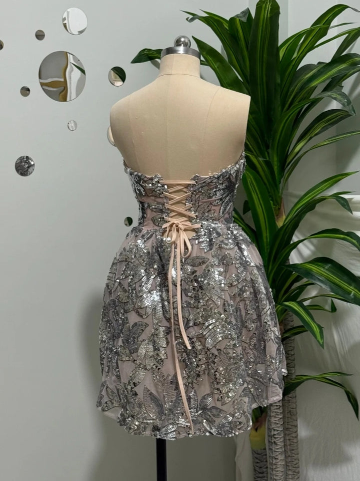Silver sequin mini dress back view with crisscross lace-up detail and flared skirt