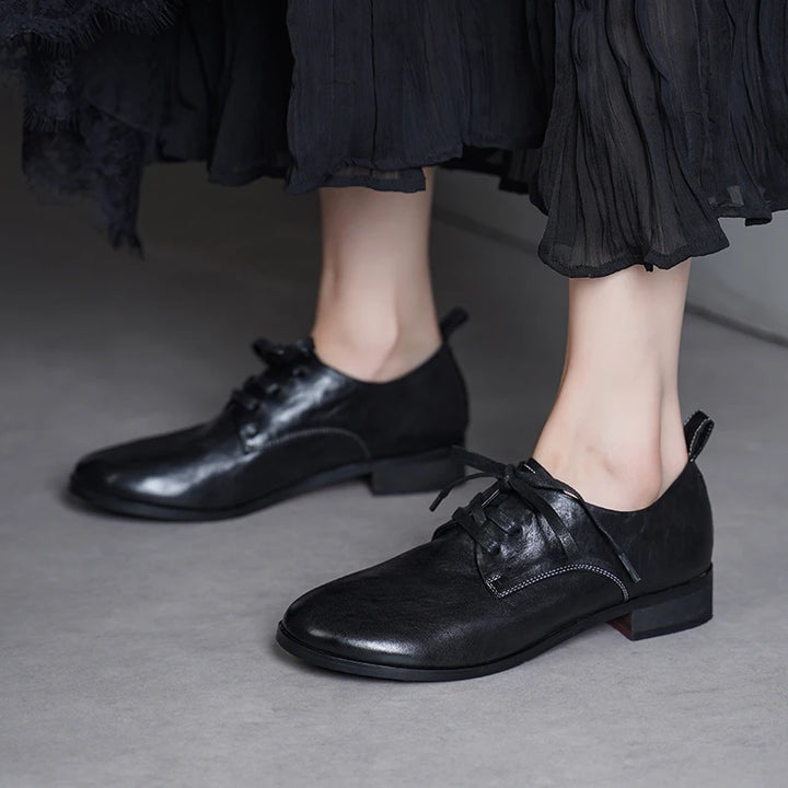 Black leather lace-up flat shoes with lace-up detail and low profile heel