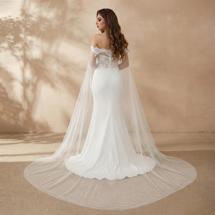 Off-white bridal dress with flowing sheer tulle veil and lace neckline from side view