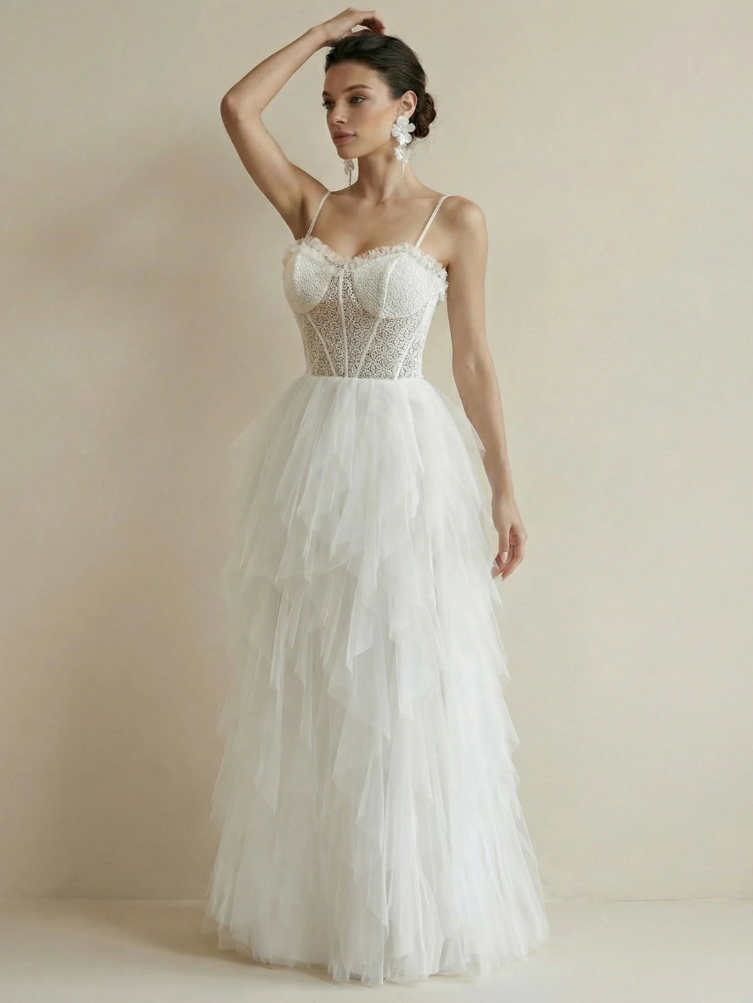 White tulle tiered ruffled bridal gown with corset-style lace bodice and spaghetti straps