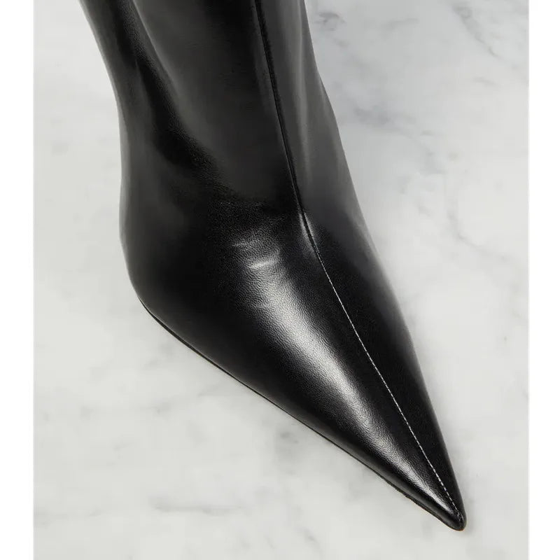 Close-up of black pointed toe and side seam on heeled ankle boot