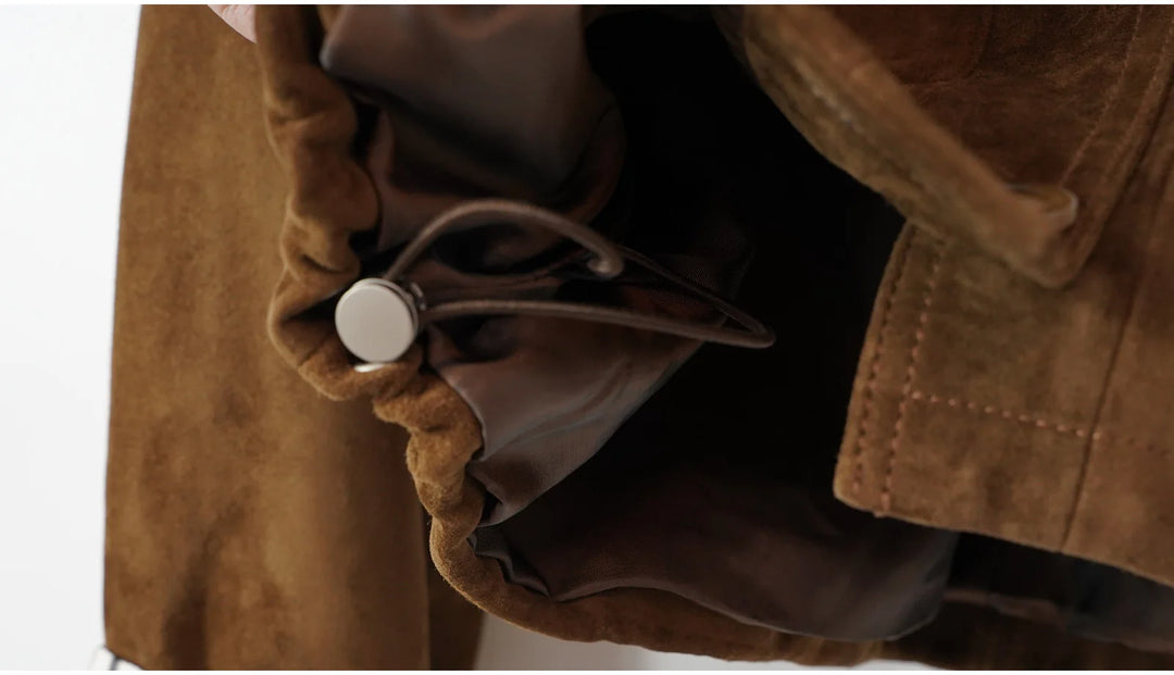 Close-up of brown suede coat sleeve cuff and inner striped lining